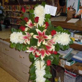 Standing floral cross with white chrysanthemums, red roses, and pink lilies