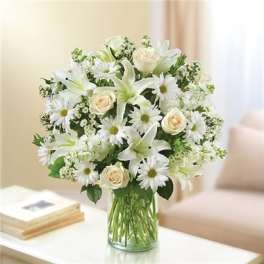 White lilies, daisies, and cream roses in a glass vase