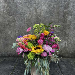 Colorful mixed flower arrangement in a woven basket
