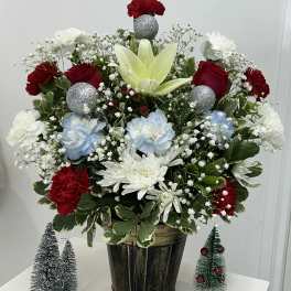 Mixed floral arrangement in a dark pot with red, white, and blue blooms