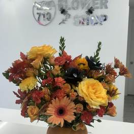 Autumn bouquet of yellow roses, gerbera daisy, and mixed blooms in a round vase