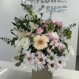 Mixed pink and white flowers in a beige box with a ribbon