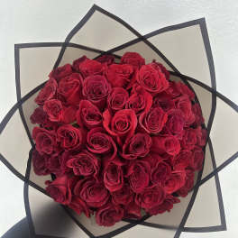Bouquet of red roses wrapped in black-edged paper