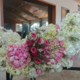 Large floral arrangement of white and pink flowers on a stand