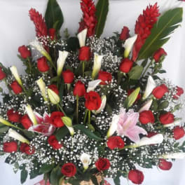 Tall basket arrangement of red roses, white calla lilies, and pink lilies with baby’s breath
