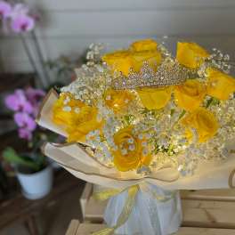 Yellow roses with baby's breath and a jeweled tiara in wrapped bouquet