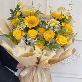 Bouquet of yellow roses and a sunflower wrapped in beige paper