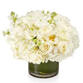 White floral arrangement in a green glass vase