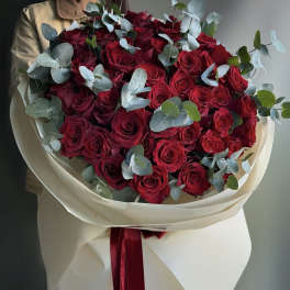 Bouquet of red roses with eucalyptus in cream wrapping