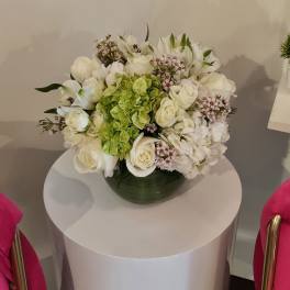 White floral arrangement with green hydrangea in a dark vase