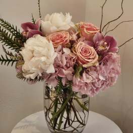 Pink and white floral arrangement in a clear glass vase