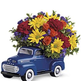 Blue vintage truck filled with colorful flowers