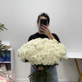 Large bouquet of white roses held by a person taking a mirror selfie