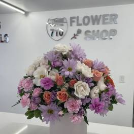 Pastel bouquet of daisies, roses, and carnations in a white box vase