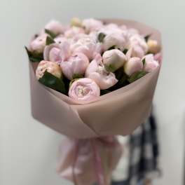Bouquet of pale pink peonies wrapped in blush paper