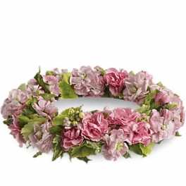 Pink floral wreath with green leaves on a white background