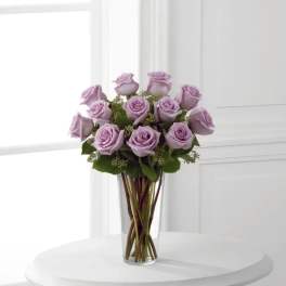 Lavender roses arranged in a clear glass vase