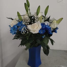 White roses and blue flowers in a blue vase