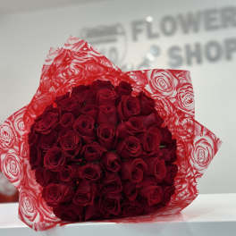 Bouquet of red roses wrapped in red patterned paper