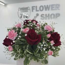 Bouquet of red roses and pink carnations in a white box
