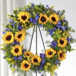 Sunflower wreath with blue and yellow flowers on a stand