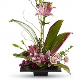 Pink lilies arranged in a black rectangular vase