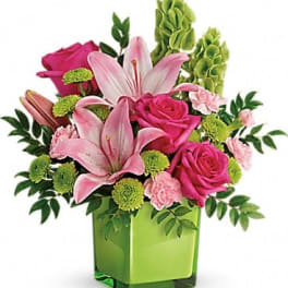 Pink lilies and roses in a green square vase