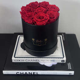Red roses arranged in a black round box