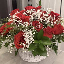 Red roses and baby's breath in a white basket