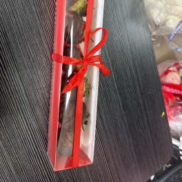 Long red gift box with roses tied with a red ribbon
