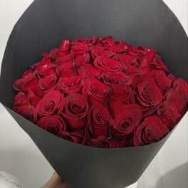 Bouquet of red roses wrapped in black paper