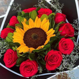 Bouquet of red roses surrounding a sunflower