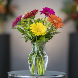 Colorful gerbera daisies in a clear glass vase