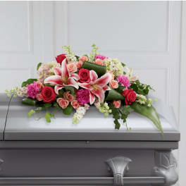 Pink and red floral casket spray with lilies and roses