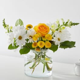 Yellow rose and white daisy bouquet in a clear glass vase