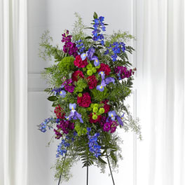 Tall standing floral spray with blue, purple, and pink flowers