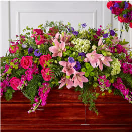 Large casket spray with pink lilies, roses, and purple flowers