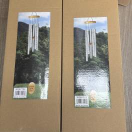 Two cardboard boxes with pictures of silver wind chimes on the front.