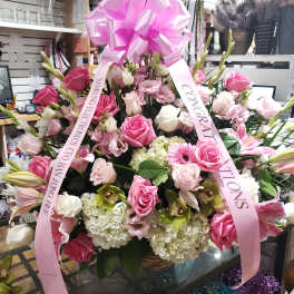 Large pink and white floral arrangement with a pink bow and ribbons