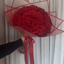 Large bouquet of red roses wrapped in red-edged paper
