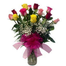 Bouquet of multicolored roses in a glass vase with a pink bow