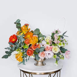 Colorful floral arrangement in a metal vase on a round table