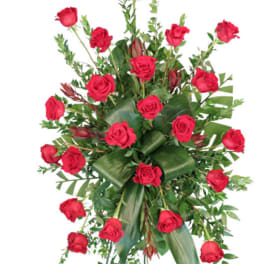 Standing spray of red roses with greenery on an easel