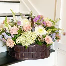 Basket of pastel roses, white blooms, and lavender flowers