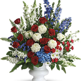 Large mixed floral arrangement in a white pedestal vase