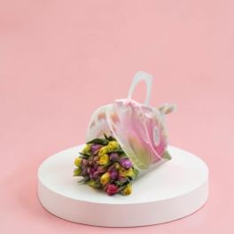 Bouquet of pink, yellow, and purple tulips in a sheer tote bag