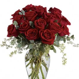 Red roses arranged in a clear glass vase