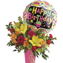 Birthday balloon above a colorful flower arrangement in a pink vase