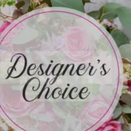 Round floral sign reading "Designer’s Choice" over pink flowers