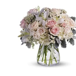 Bouquet of pale pink and white flowers in a clear glass vase